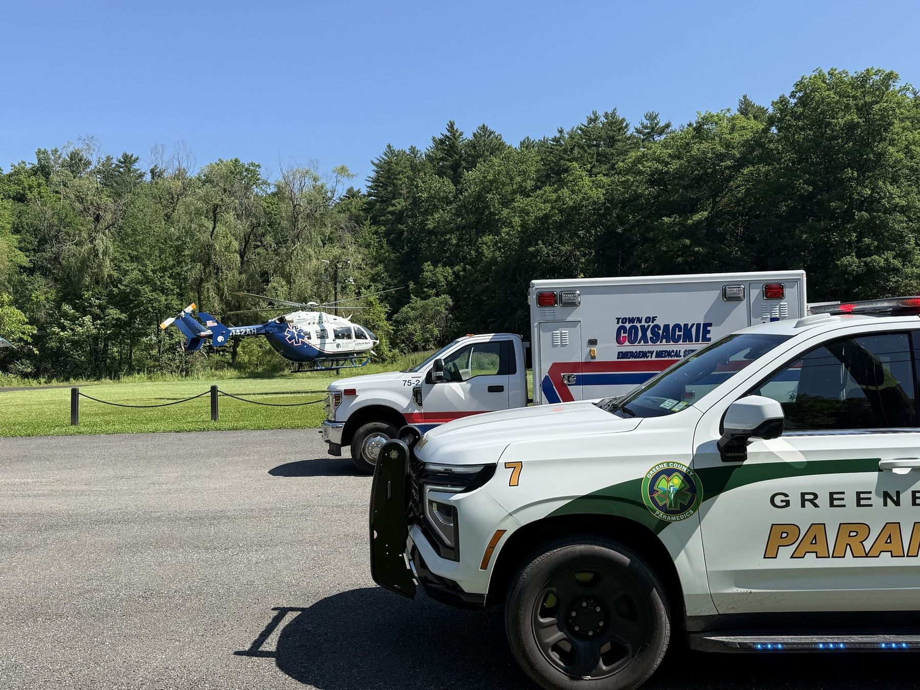 Medic 7 beside a Town of Coxsackie ambulance with a medical helicopter landing behind