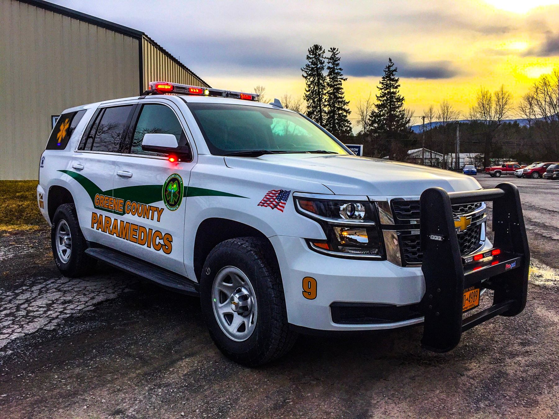 Medic 9, a Chevrolet Tahoe in the 2010s green-and-gold graphic scheme, at sunset outside the Hunter station