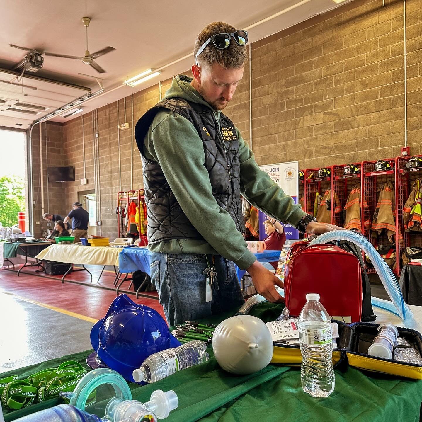A Greene County paramedic setting up an outreach table with equipment at a firehouse