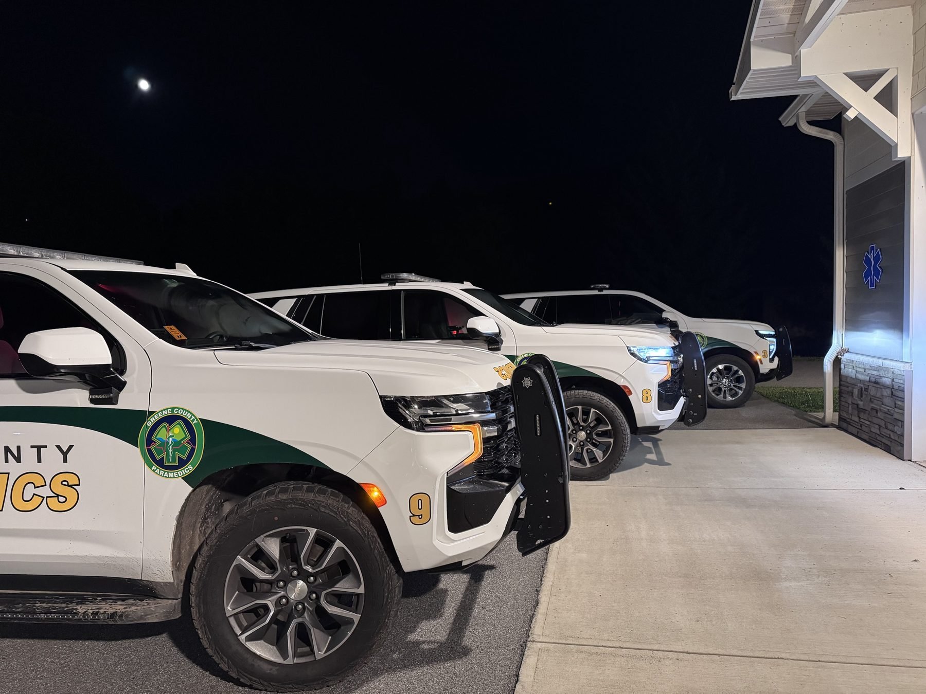 Three GCEMS fly cars lined up outside a station at night